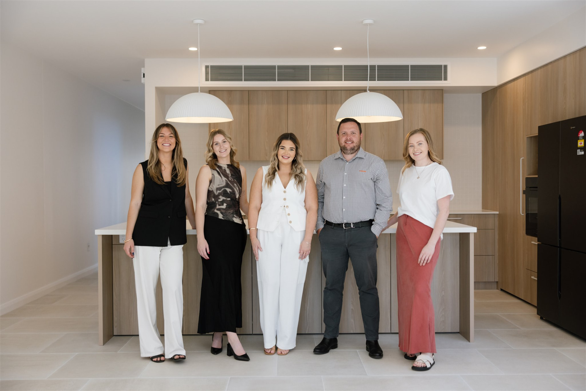 Leah Jay property management team standing in a newly built kitchen