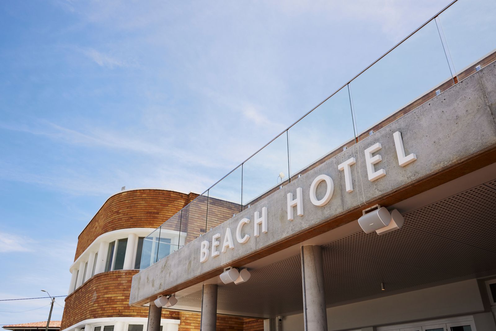 The Beach Hotel Merewether exterior signage against a blue sky